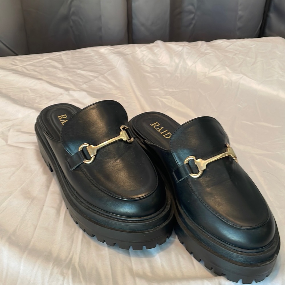 Black platform mules with horsebit detail.